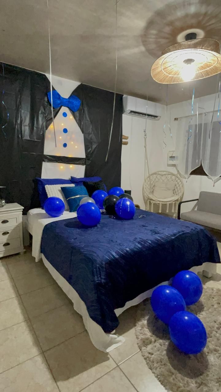 Décoration EVG : smoking, ballons bleus et noirs sur lit marine