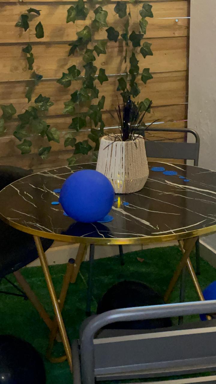 Table marbre noire avec ballon bleu et lierre suspendu