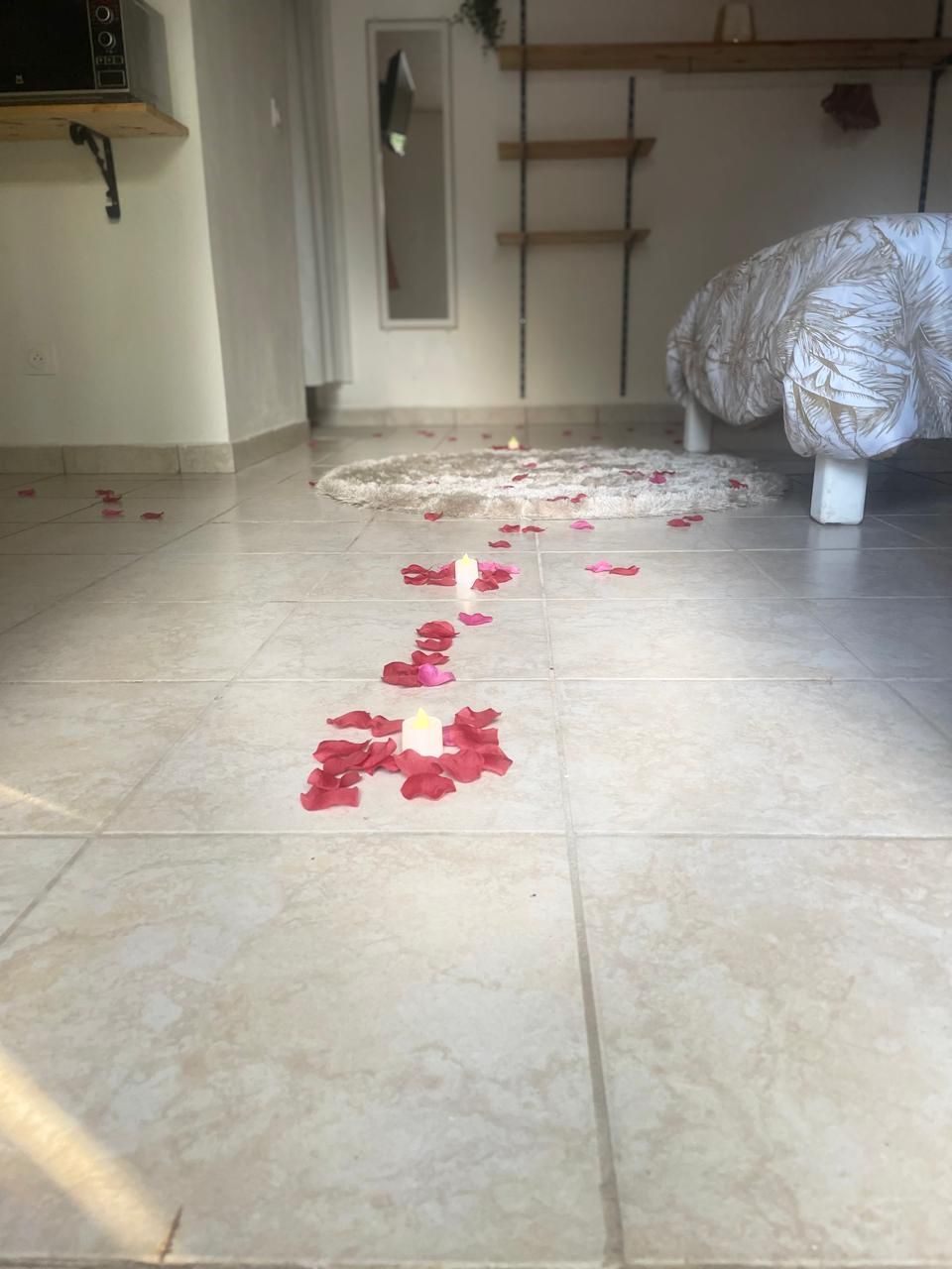 Décoration romantique : pétales de roses et bougies au sol